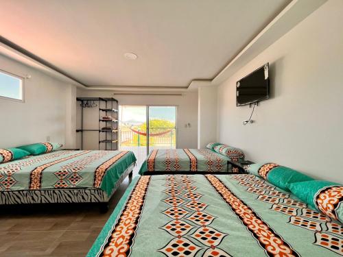 a room with two beds and a flat screen tv at Casa Halley #4 con vista al mar y piscina , 2 pisos - Villamil Playas , Data de Villamil in Playas