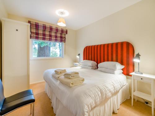 a bedroom with a bed with towels on it at Burnside West Cottage- Uk39596 in Strathkinness