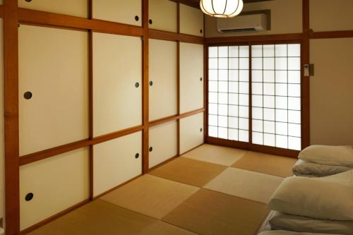 a living room with white cabinets and a window at Seaside Villa SASAO in Aji