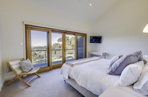 a bedroom with a large bed and a large window at Seascape Retreat in Victor Harbor