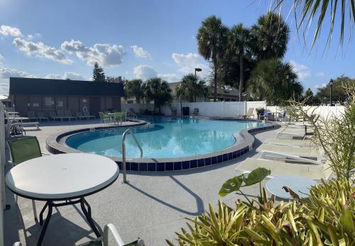 a swimming pool with tables and chairs in a resort at LIBERTY INN in Kissimmee