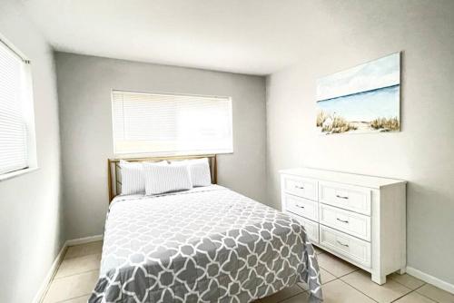 1 dormitorio con 1 cama, vestidor y ventana en Sun, Sand, Coastal Haven 1 en Clearwater Beach