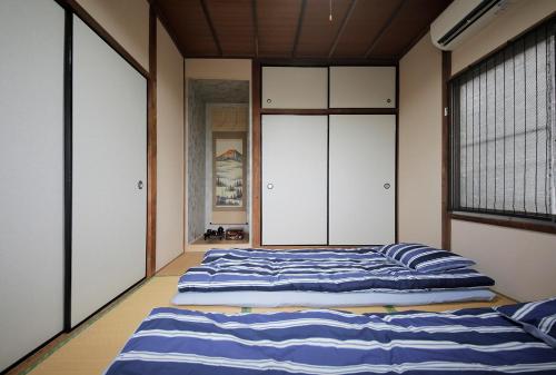 A bed or beds in a room at 2F SAKURA RIVER HOUSE, yao 桜と川の家 2F