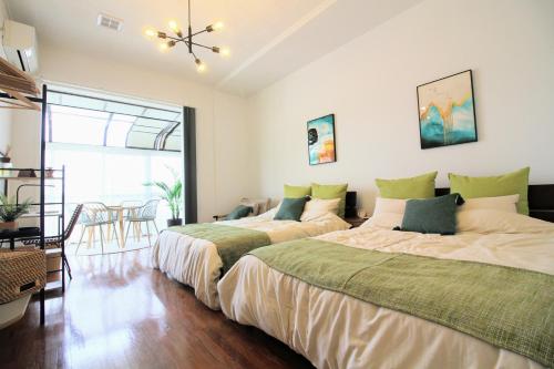 沖縄市にあるGuest room MINAMI 沖縄のベッドルーム(ベッド2台、テーブル、椅子付)