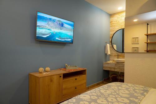um quarto com uma televisão na parede e um lavatório em U-GO Casa Ramona frente al Club Nautico de Cartagena em Cartagena das Índias