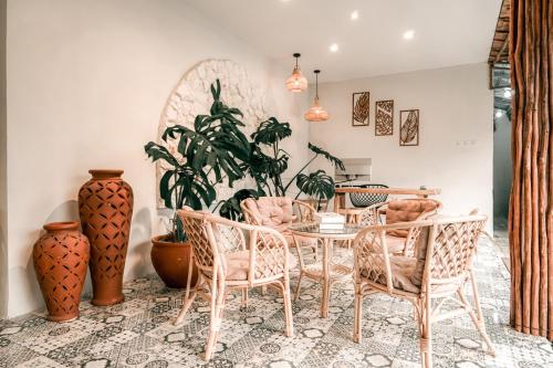 une salle à manger avec une table, des chaises et des vases dans l'établissement Demoska Villa Jogja With Privatepool, à Kejayan