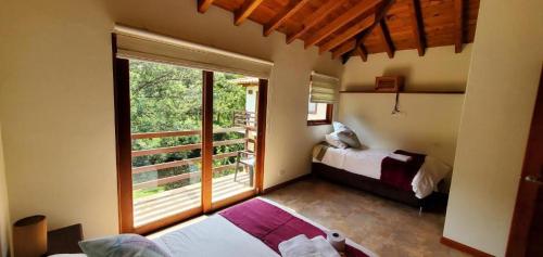 sypialnia z 2 łóżkami i dużym oknem w obiekcie Las Marías ApartaSuites w mieście Villa de Leyva