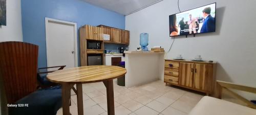 a kitchen with a table and a tv on a wall at Apart Eco Estudio Joocah in Trujillo