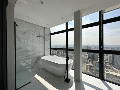 baño con bañera y ventana grande en Sky Loft - Andar 41, en São Paulo