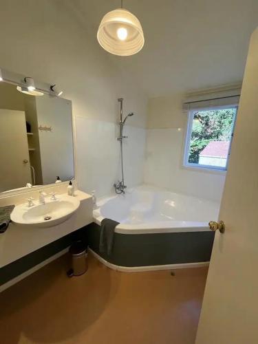 a bathroom with a tub and a sink and a mirror at The Loft @ Gladstone Vineyard in Gladstone