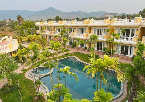 an aerial view of a resort with a pool and palm trees at Sokchea Kampot Hotel in Kampot