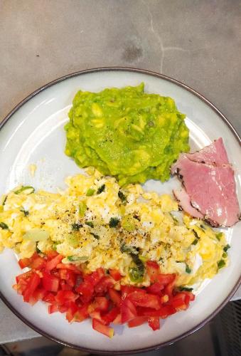 a plate of food with eggs ham and vegetables at Ampersand Resort in Bophut 