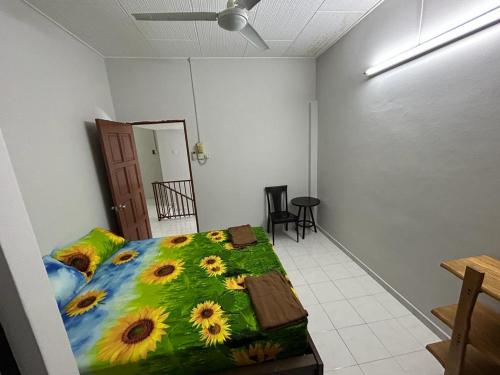 a bedroom with a bed with a sunflower blanket at Muhibbah Homestay in Sungai Siput