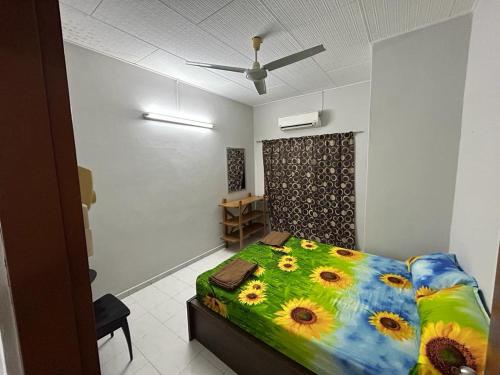 a bedroom with a bed with a colorful comforter at Muhibbah Homestay in Sungai Siput