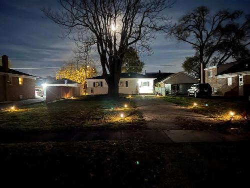 a house with lights in the yard at night at Modern 3Bed 2Bath Ranch with DIY Art Porch 3TVs and Huge Front Yard to Enjoy! in Calumet City