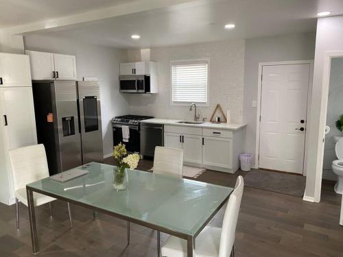 a kitchen with a glass table and white cabinets at Modern 3Bed 2Bath Ranch with DIY Art Porch 3TVs and Huge Front Yard to Enjoy! in Calumet City