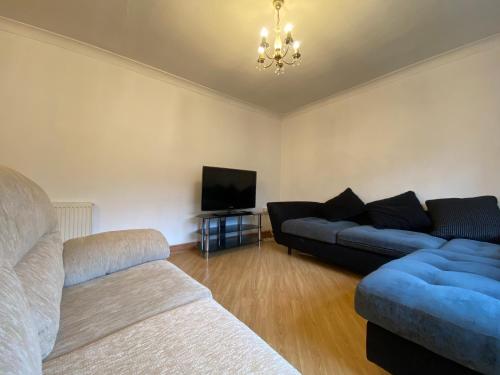 a living room with two couches and a flat screen tv at Cosy 3BR Home Close to Villa Park Castle Bromwich off the M6 in Birmingham