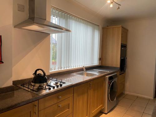 a kitchen with a sink and a stove top oven at Cosy 3BR Home Close to Villa Park Castle Bromwich off the M6 in Birmingham