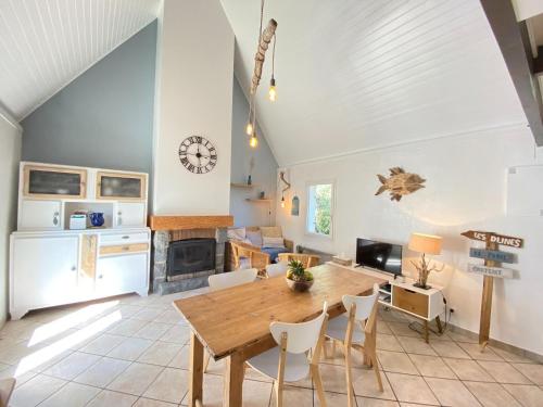 Il dispose d'une cuisine et d'un salon avec une table et des chaises en bois. dans l'établissement Holiday Home in Carteret near Dunes & Beach, à Barneville-Carteret
