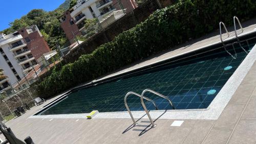una gran piscina con 2 sillas de metal al lado en Hermoso Apartamento en exclusiva zona ibague Calambeo en Ibagué