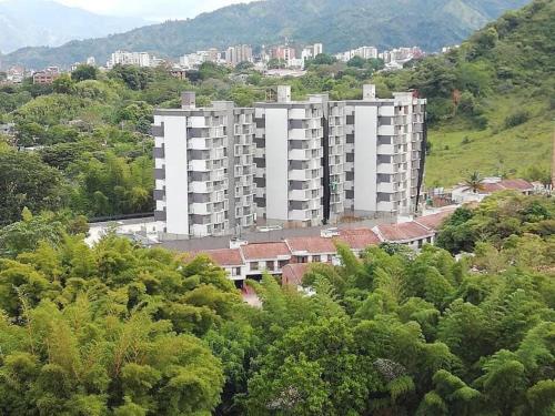un gran edificio de apartamentos blanco en una colina con árboles en Hermoso Apartamento en exclusiva zona ibague Calambeo en Ibagué