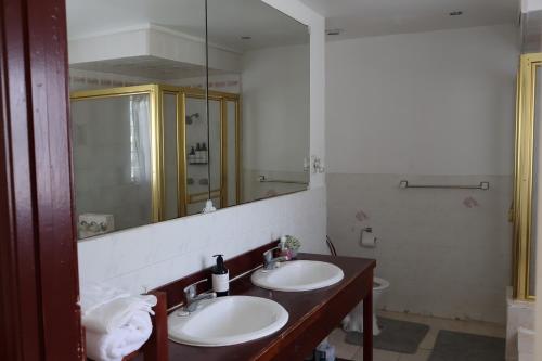 a bathroom with two sinks and a large mirror at 'Ataongo Residence in Nuku‘alofa