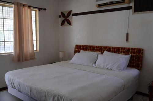 努瓜婁發的住宿－'Ataongo Residence，卧室内的一张带白色床单和枕头的床