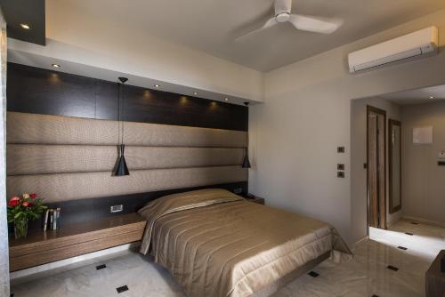 een slaapkamer met een bed met een houten hoofdeinde bij Lito Beach Hotel in Gerani Chanion