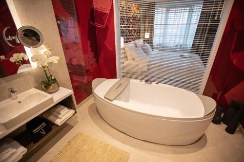 a bathroom with a large white tub and a sink at The Hunter's Lodge Kamnik in Skopje