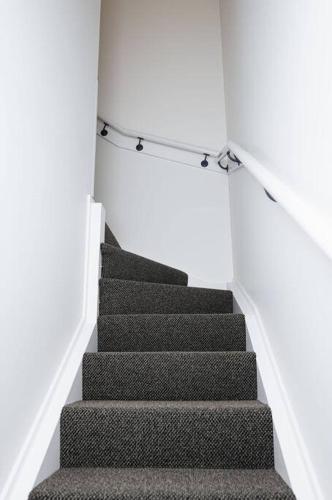 a staircase in a white room with a stair railing at Salamanca Getaway Battery Point in Hobart