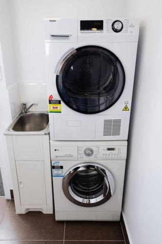 a washer and dryer next to a sink at Salamanca Getaway Battery Point in Hobart