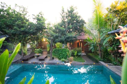 una piscina di fronte a una casa alberata di Arana Garden Ubud ad Ubud