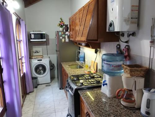 een kleine keuken met een fornuis en een wasmachine bij Casa Plantamura Vacaciones con Familia in La Cieneguita