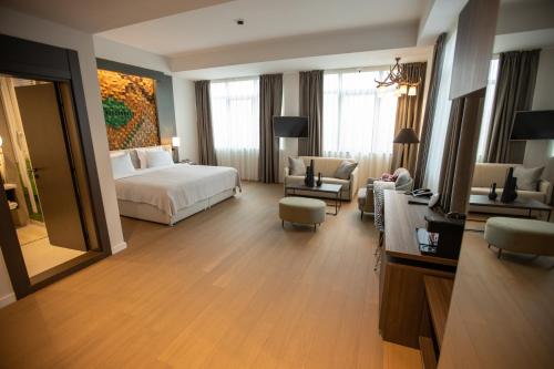 a hotel room with a bed and a living room at The Hunter's Lodge Kamnik in Skopje