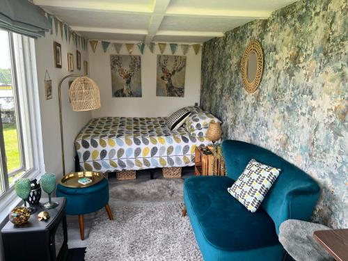 um quarto com uma cama, um sofá e uma cadeira em Bothy hut em Tring
