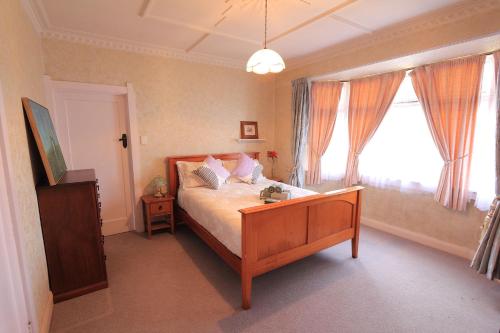 a bedroom with a bed and a large window at The southernmost home in the world in Invercargill