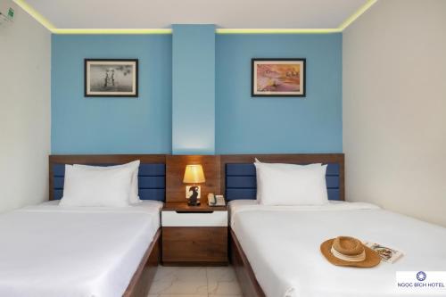ダナンにあるNgọc Bích Hotel Da Nangの青い壁のドミトリールーム ベッド2台
