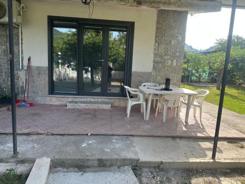 una mesa y sillas en un patio con ventana en Villa Maddy en Vibonati