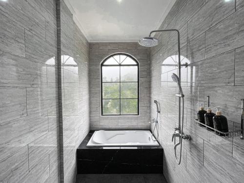 a bathroom with a bath tub and a window at Casa Rani Hotel & Restaurant in Kubupenlokan