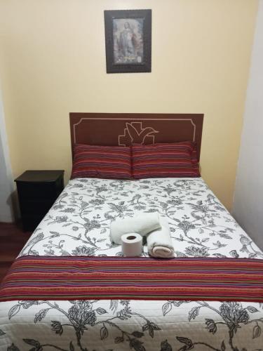 Una cama con dos toallas y dos tazas. en Hospedaje Apu Salka, en Cusco