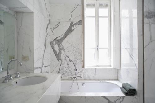 a white bathroom with a sink and a window at Ninù Roma centro storico in Rome