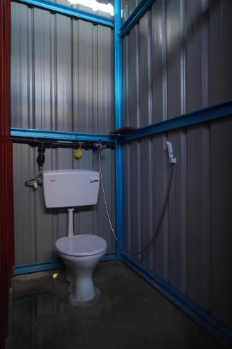 a bathroom with a toilet in a metal building at Redang Campstay Bamboo House in Redang Island