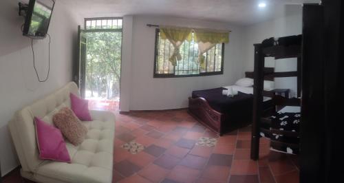 a living room with a couch and a bed at Cabañas Balconcitos in San Gil