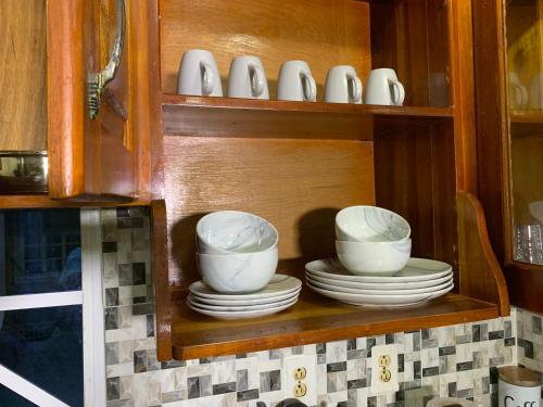 a cabinet with plates and bowls on a shelf at Relaxing 2 bedroom property for up to 4 person in Georgetown