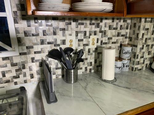 a kitchen counter with utensils in a cup at Relaxing 2 bedroom property for up to 4 person in Georgetown