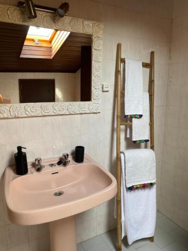 a bathroom with a sink and a mirror and towels at Silver Coast Beach House in Torres Vedras