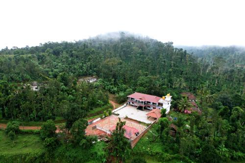 an aerial view of a house in the middle of a forest at Kotibetta Homestay - Mountains View, River & Trek in Chikmagalūr