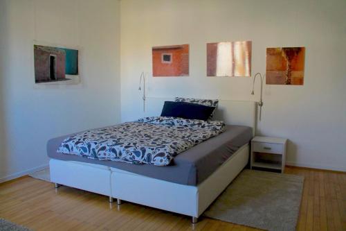Bett in einem Zimmer mit Gemälden an der Wand in der Unterkunft Pension TimeOut in Kassel