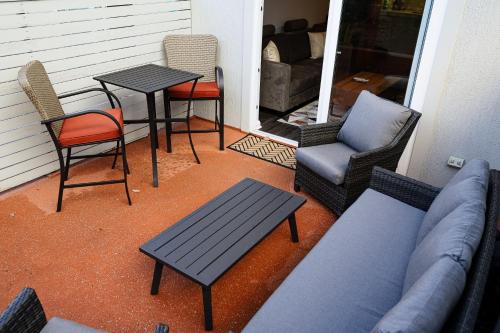 a porch with a couch and chairs and a table at Salamanca Getaway Battery Point in Hobart