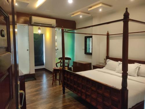 a bedroom with a bed with a wooden frame at Zoom Inn Heritage in Puducherry